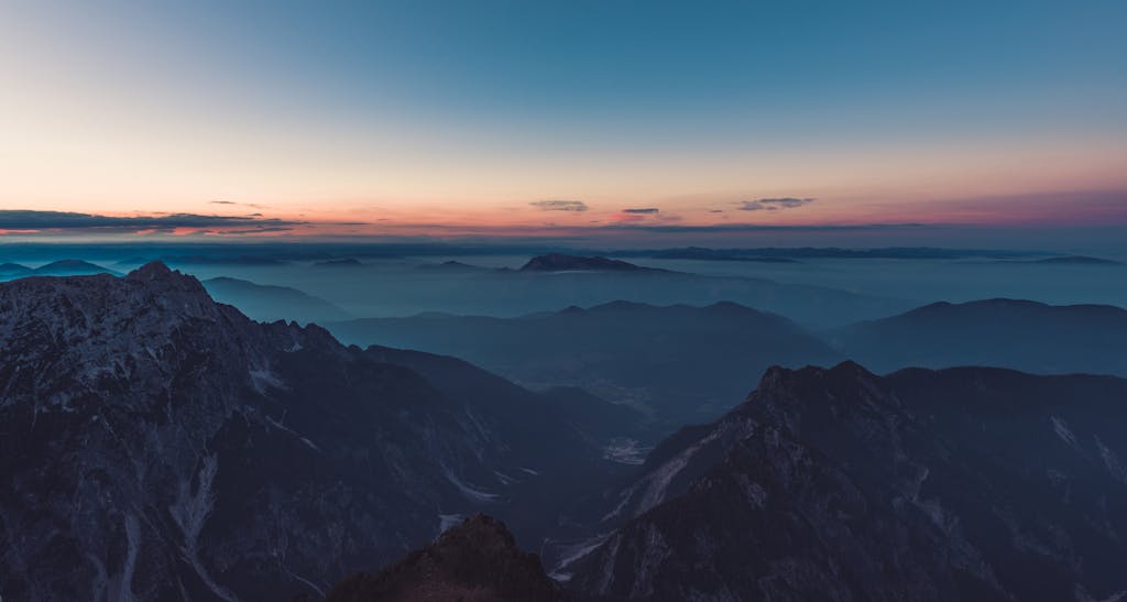 Stunning aerial view of misty mountains at twilight, capturing serene nature.